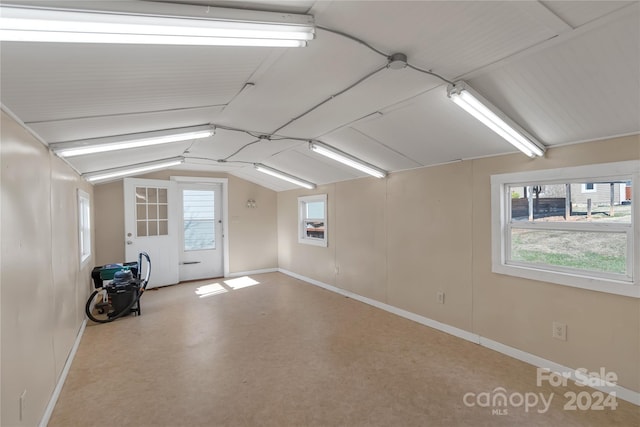 additional living space featuring concrete floors and vaulted ceiling