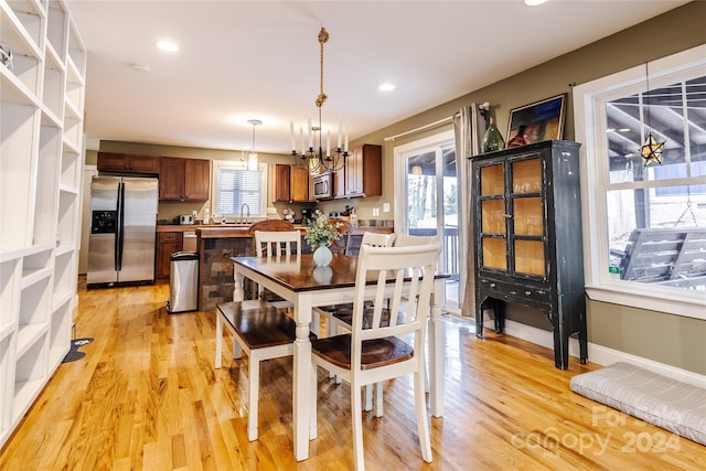 dining room featuring a chandelier, light hardwood / wood-style floors, and sink