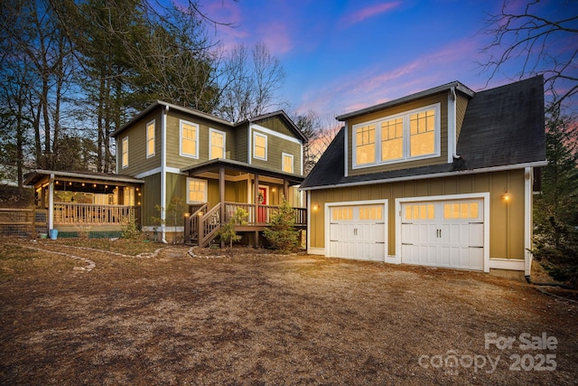 back house at dusk featuring a garage and covered porch