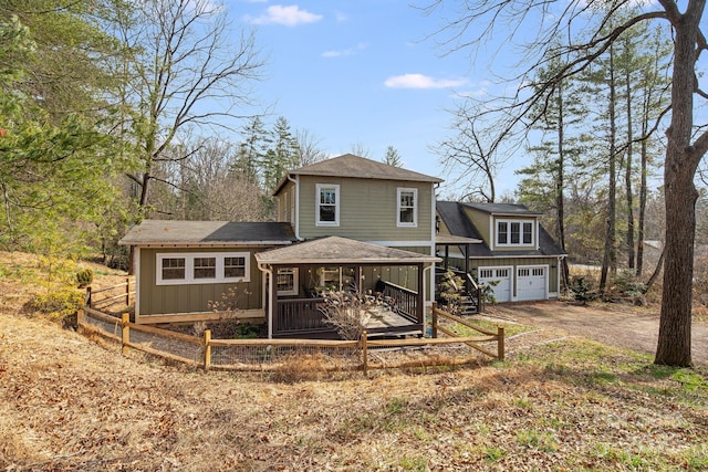 back of house featuring a garage and a deck