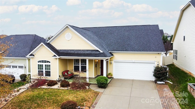 view of front of house featuring a front lawn, covered porch, and a garage