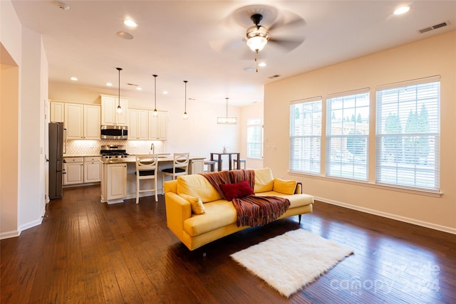 living room with dark hardwood / wood-style floors and ceiling fan