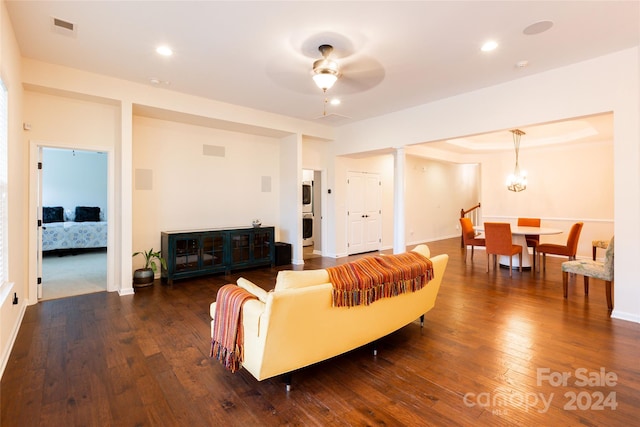 living room featuring decorative columns, ceiling fan, and dark hardwood / wood-style flooring