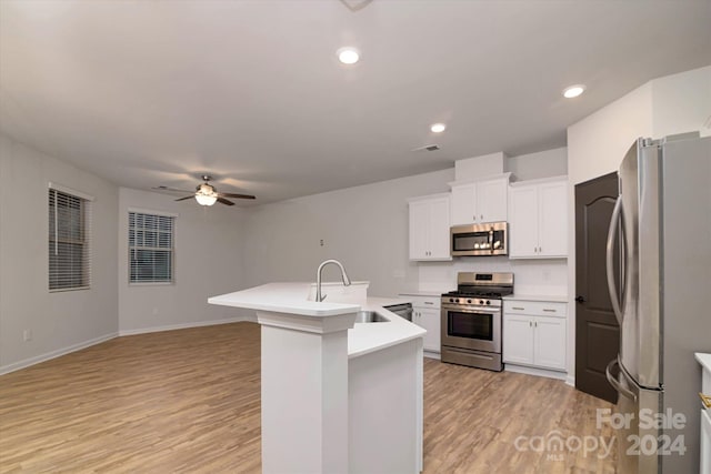 kitchen with white cabinetry, ceiling fan, sink, stainless steel appliances, and light wood-type flooring