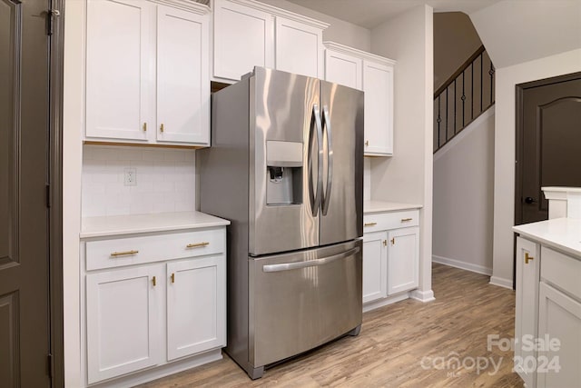 kitchen with white cabinetry, decorative backsplash, stainless steel fridge with ice dispenser, and light hardwood / wood-style floors