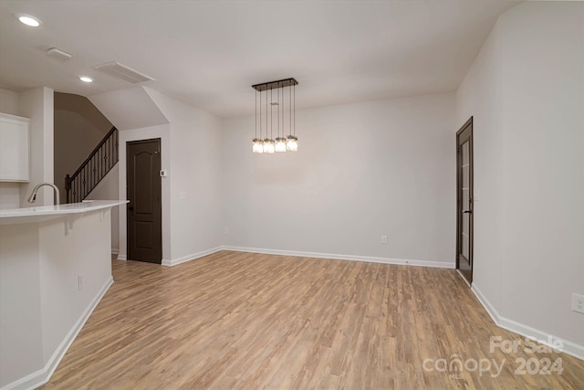 spare room featuring sink and light wood-type flooring