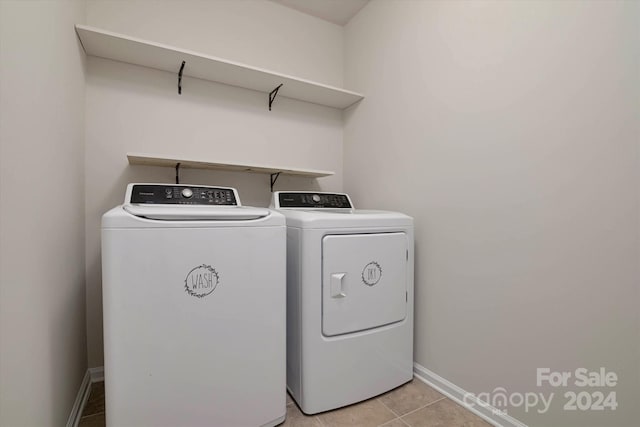 clothes washing area with washer and dryer and light tile patterned floors