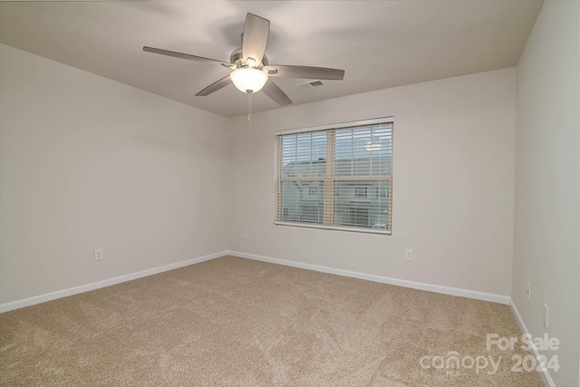 carpeted spare room featuring ceiling fan