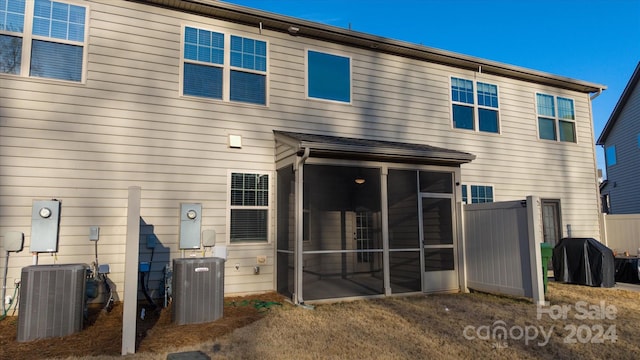 rear view of house featuring a sunroom and central AC unit