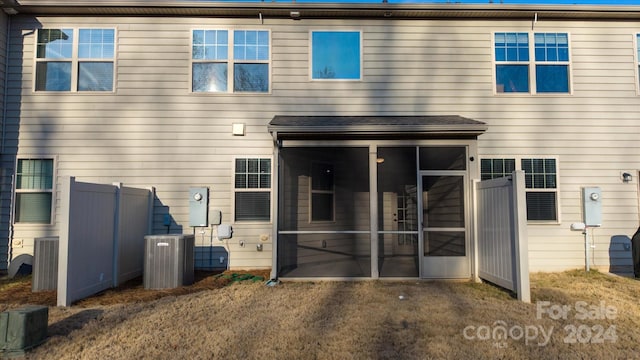 rear view of house featuring central AC and a sunroom