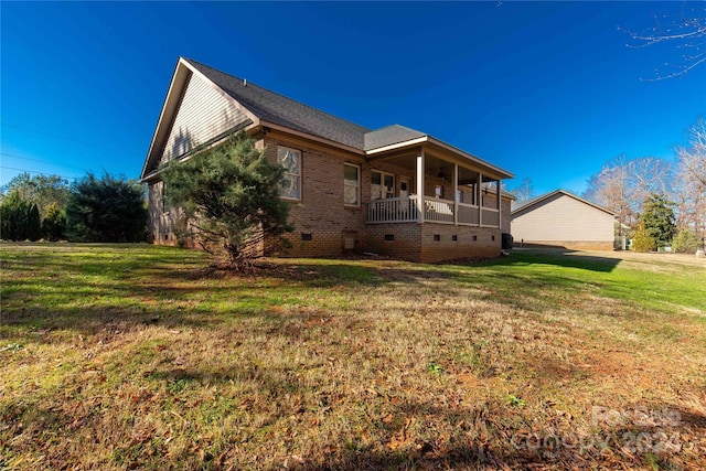 view of side of home with a porch and a yard