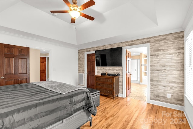 bedroom featuring ceiling fan, light hardwood / wood-style flooring, and wooden walls