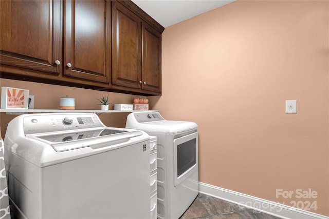 laundry room featuring washing machine and clothes dryer and cabinets