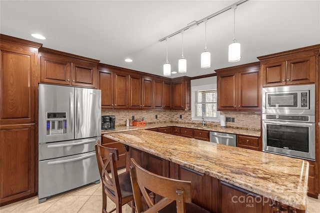 kitchen featuring sink, decorative backsplash, light tile patterned floors, appliances with stainless steel finishes, and light stone counters