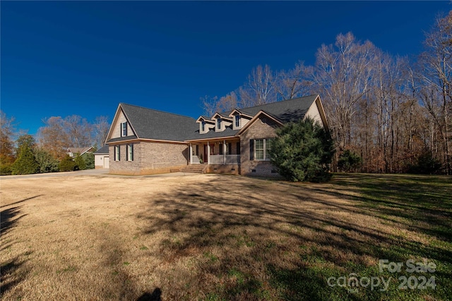 view of side of home featuring a lawn and covered porch