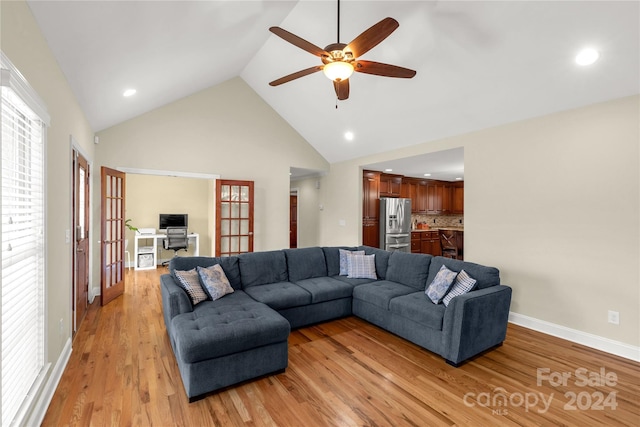 living room featuring french doors, light hardwood / wood-style floors, high vaulted ceiling, and ceiling fan