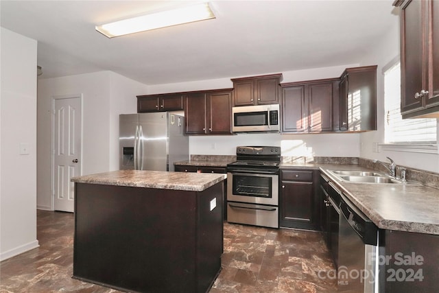 kitchen featuring dark brown cabinetry, a center island, stainless steel appliances, and sink