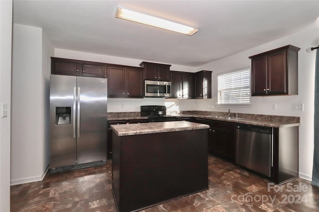 kitchen with dark brown cabinets, a kitchen island, sink, and appliances with stainless steel finishes