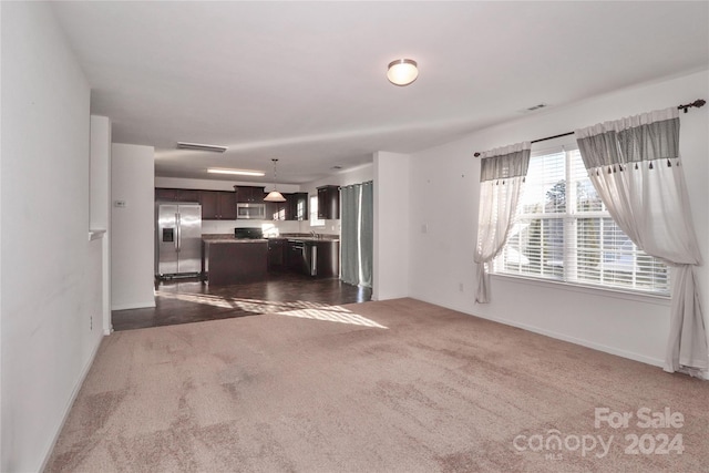 unfurnished living room featuring dark carpet and sink