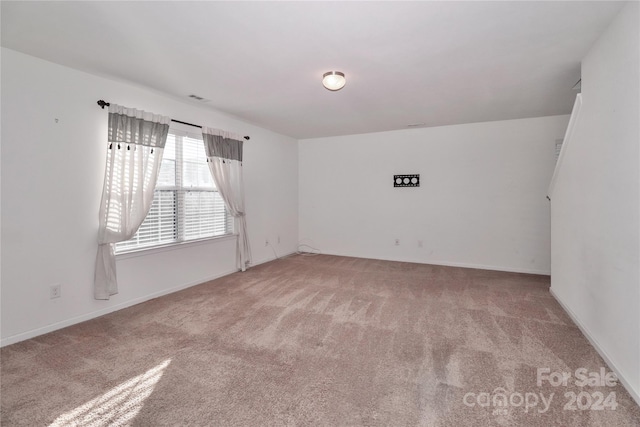 unfurnished room featuring light colored carpet