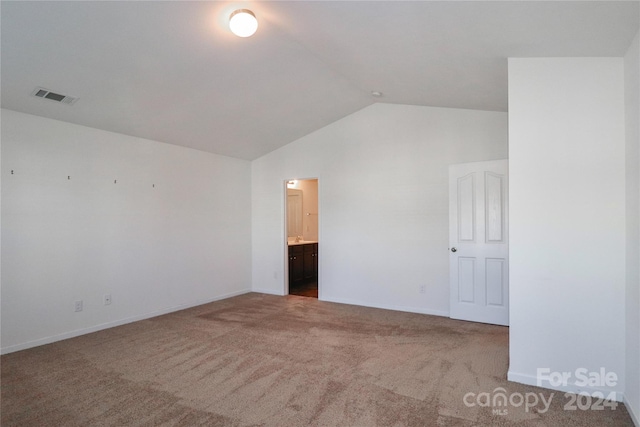 carpeted spare room with lofted ceiling