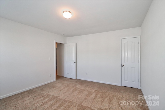 unfurnished room featuring light colored carpet