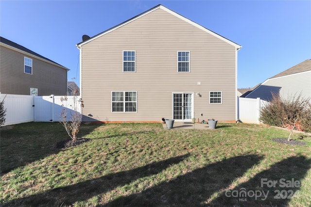 back of house with a yard and a patio