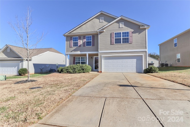 front facade featuring a front yard, a garage, and cooling unit