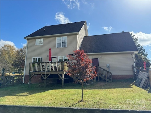 rear view of house with a deck and a yard