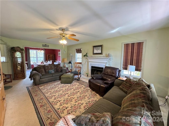 living room with light colored carpet, ceiling fan, a healthy amount of sunlight, and a premium fireplace