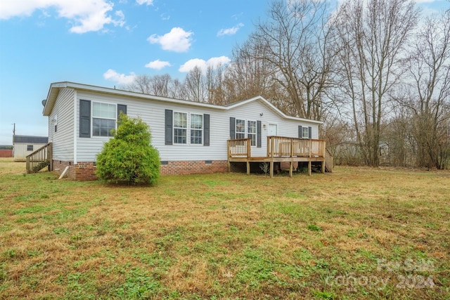 back of house featuring a yard and a wooden deck