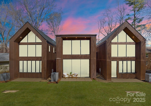 back of property featuring a yard, central AC, and an outdoor structure