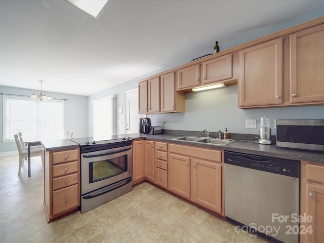 kitchen with kitchen peninsula, stainless steel appliances, an inviting chandelier, and sink