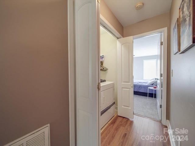 hall featuring washer / dryer and light hardwood / wood-style flooring