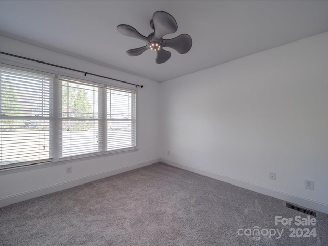 carpeted spare room featuring ceiling fan