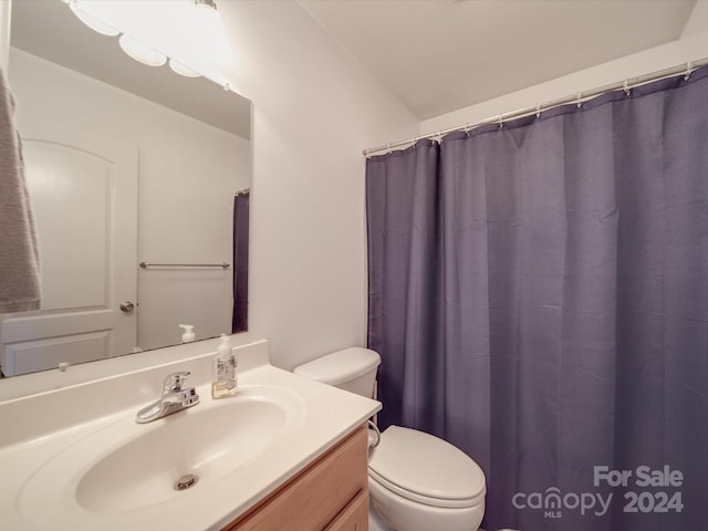 bathroom featuring a shower with curtain, vanity, and toilet