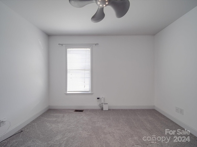 spare room with ceiling fan and light colored carpet