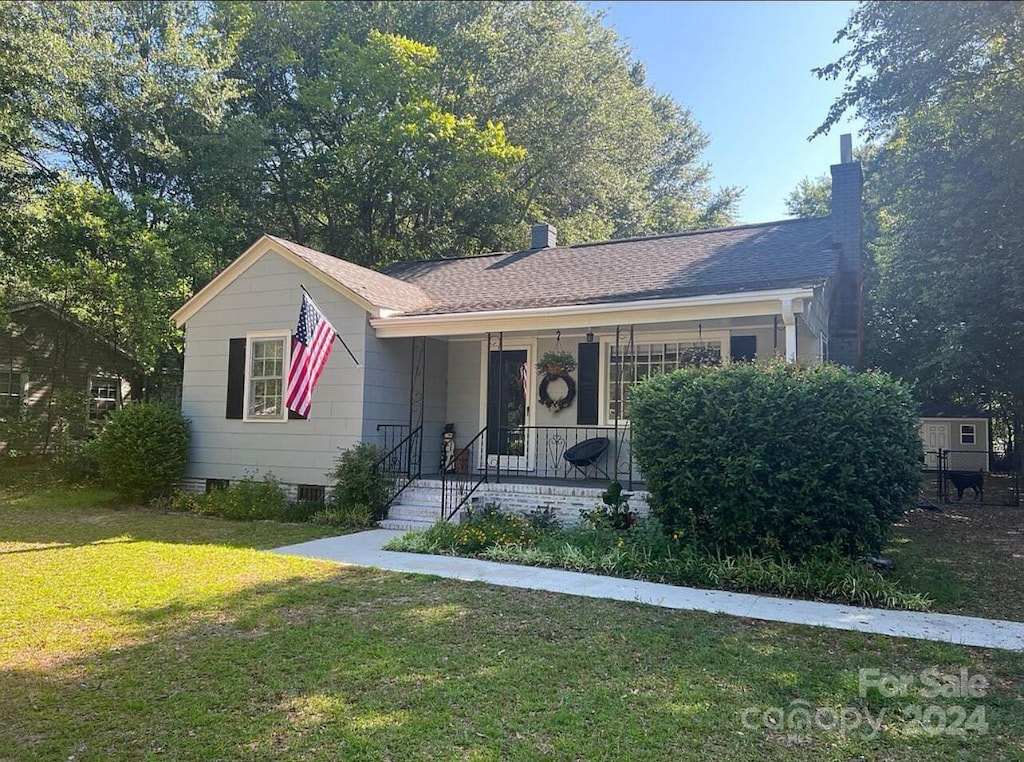 single story home with a porch and a front yard