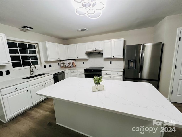 kitchen featuring sink, light stone counters, a kitchen island, and black appliances