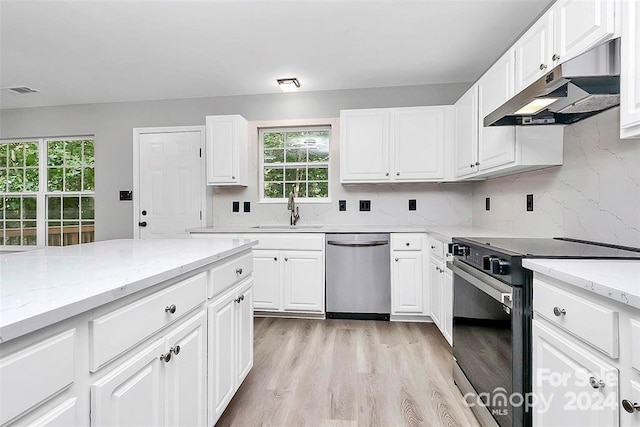 kitchen with white cabinetry, sink, stainless steel appliances, and light hardwood / wood-style flooring