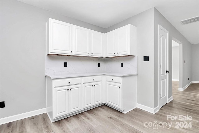 clothes washing area with light hardwood / wood-style floors