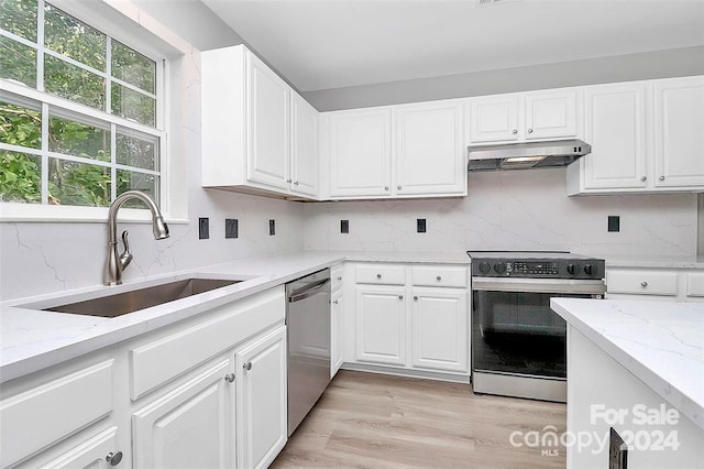 kitchen featuring sink, white cabinets, light hardwood / wood-style floors, and appliances with stainless steel finishes