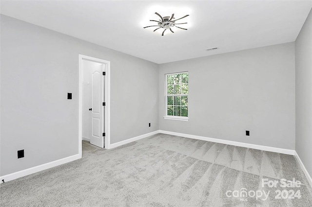 carpeted spare room featuring ceiling fan