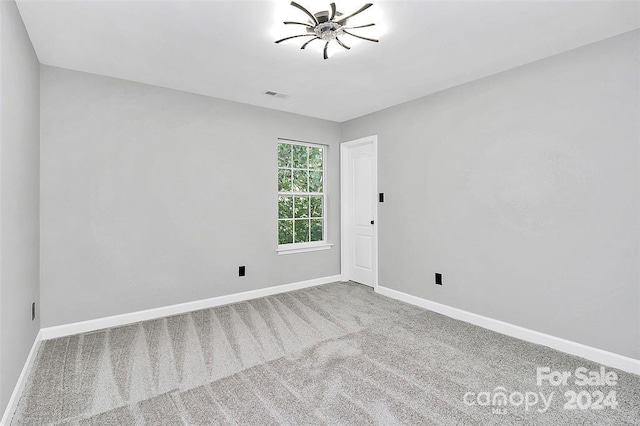 carpeted empty room featuring ceiling fan