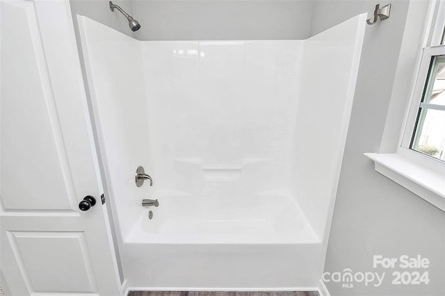 bathroom featuring hardwood / wood-style floors and  shower combination