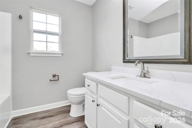 bathroom with hardwood / wood-style flooring, vanity, and toilet