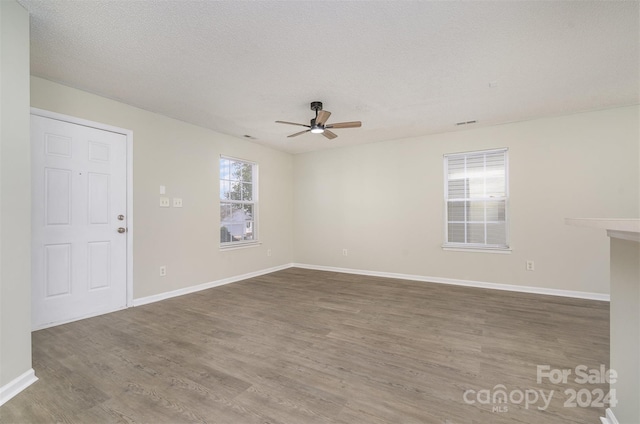 spare room with hardwood / wood-style floors, a textured ceiling, plenty of natural light, and ceiling fan