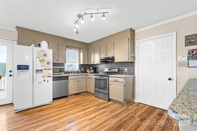 kitchen featuring appliances with stainless steel finishes, ornamental molding, a textured ceiling, sink, and light hardwood / wood-style flooring