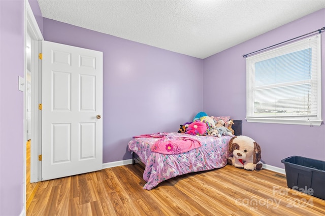 bedroom with hardwood / wood-style flooring and a textured ceiling