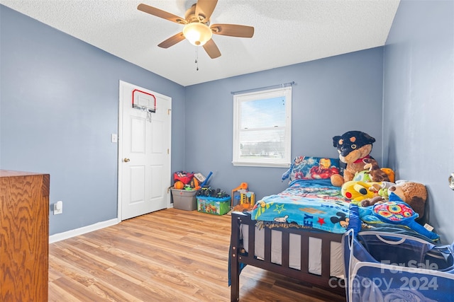 bedroom with hardwood / wood-style floors, a textured ceiling, and ceiling fan